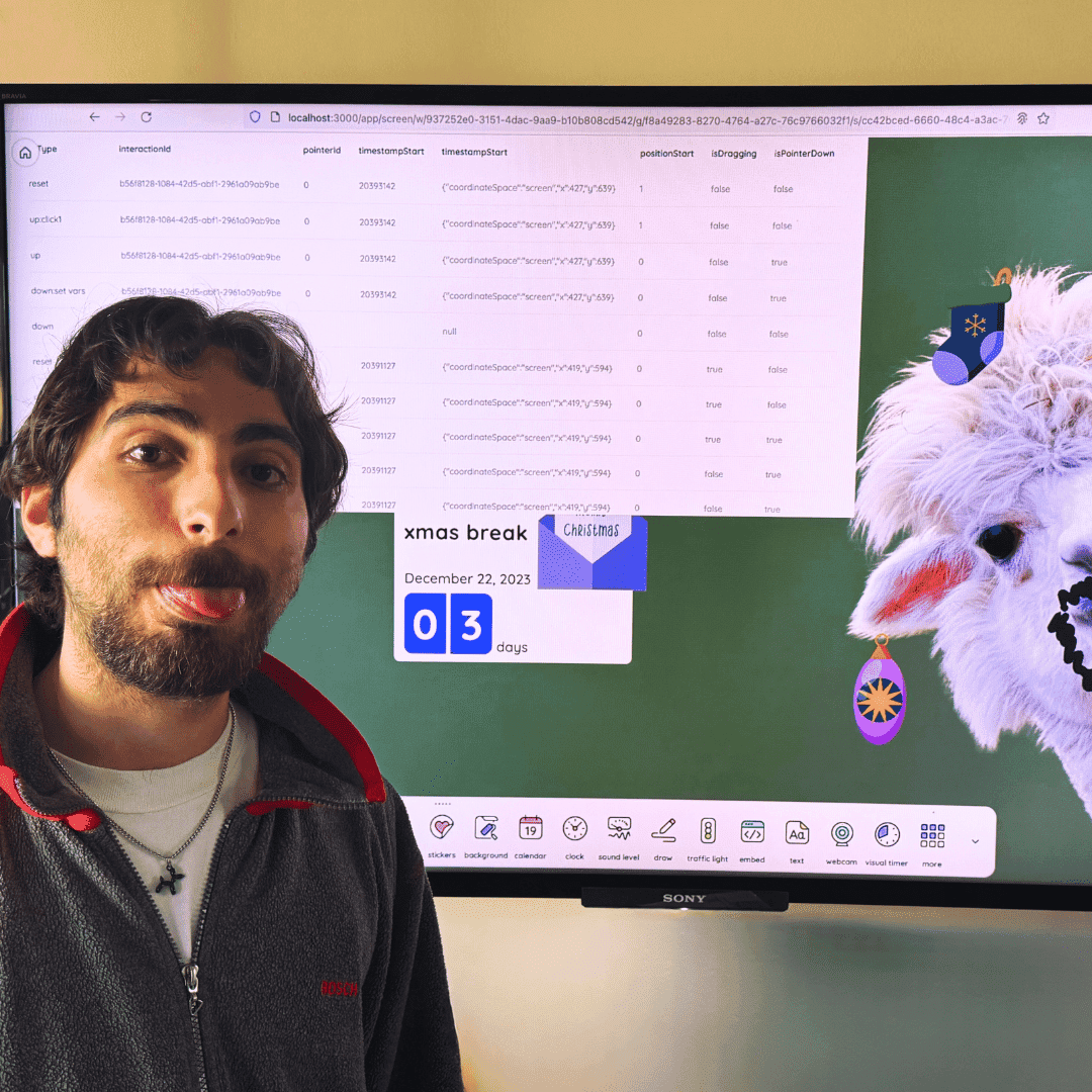 Hayk is standing in front of his Classroomscreen, which has a fabulous llama with a matching goatee.